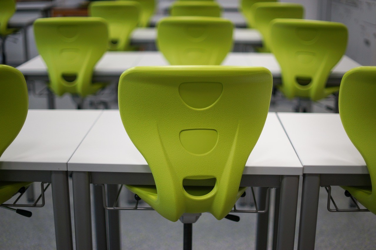 green chairs and white desks in the empty test room