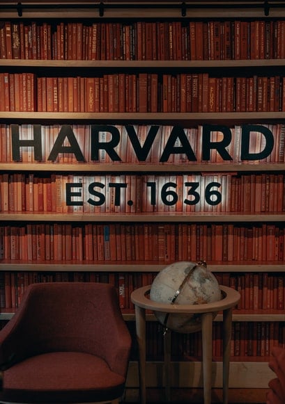 Harvard sign in front of the shelves with books
